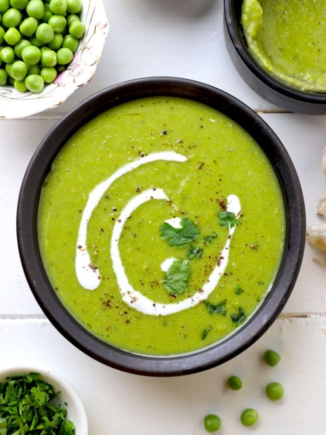 aerial shot of green pea soup served in a black ceramic bowl