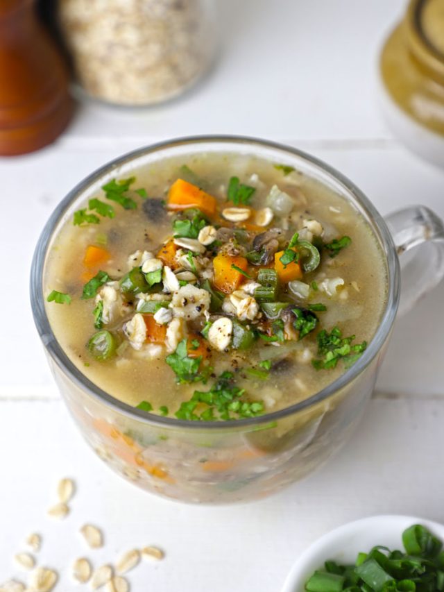 side shot of vegetable oats soup in a glass mug