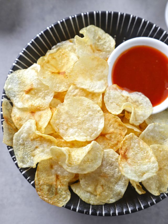 aerial shot of potato chips with ketchup in a bowl