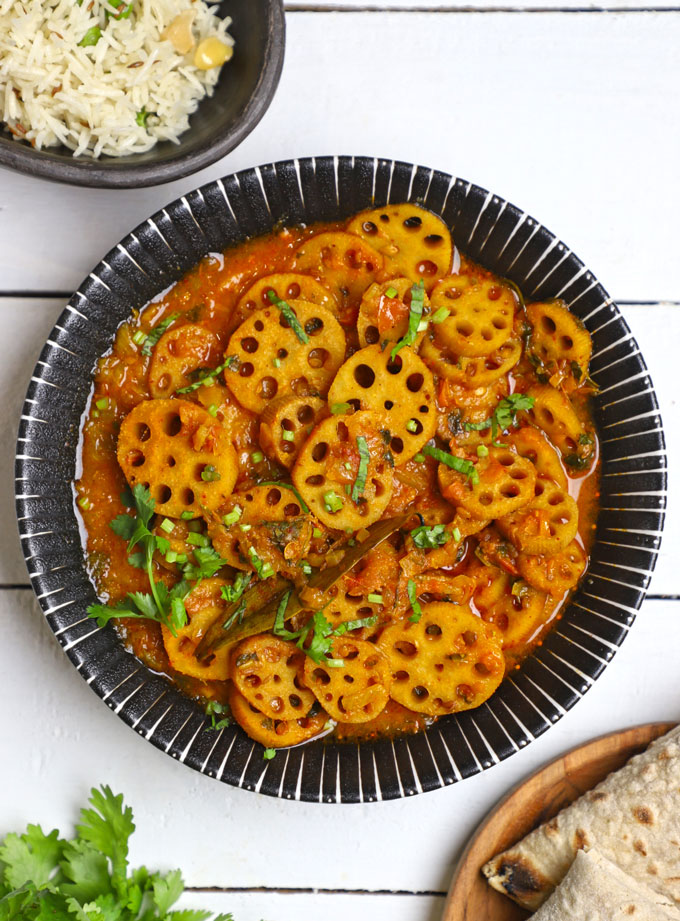 aerial shot of kamal kakdi ki sabji in a black ceramic bowl