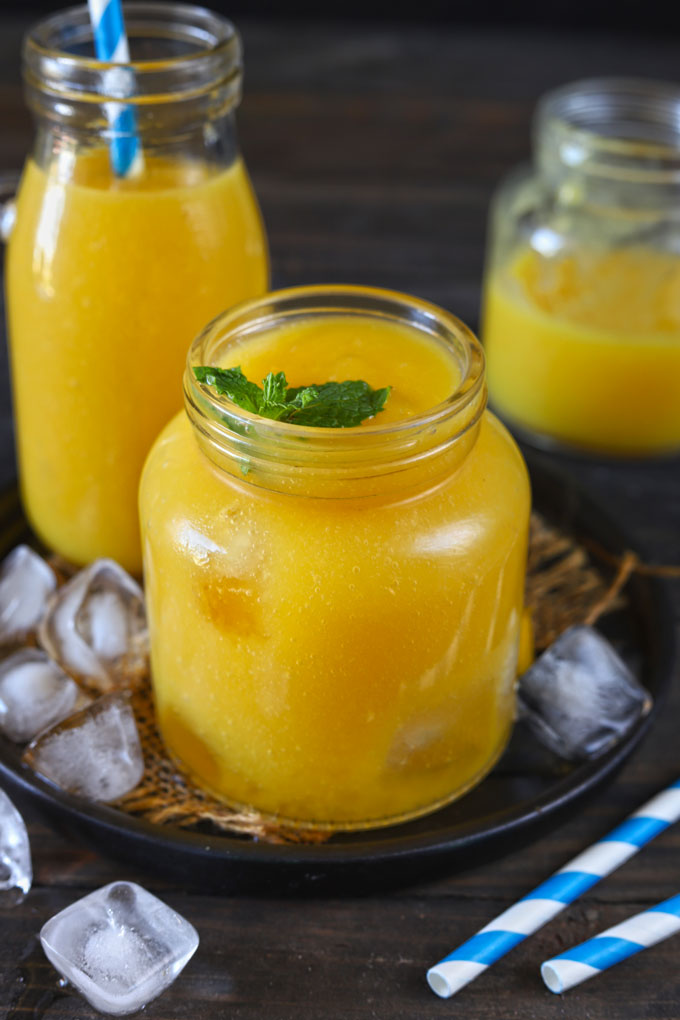 Aerial/side shot of mango iced tea in a glass bottle.