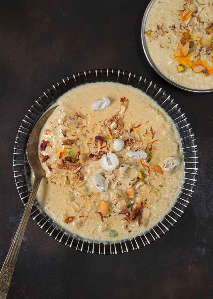 aerial shot of makhana kheer in a black ceramic bowl with a spoon