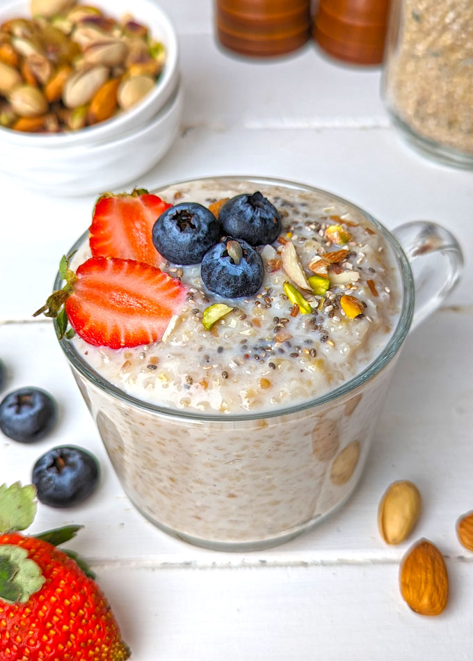side shot of sweet dalia recipe in a glass mug topped with chia seeds and fresh fruits